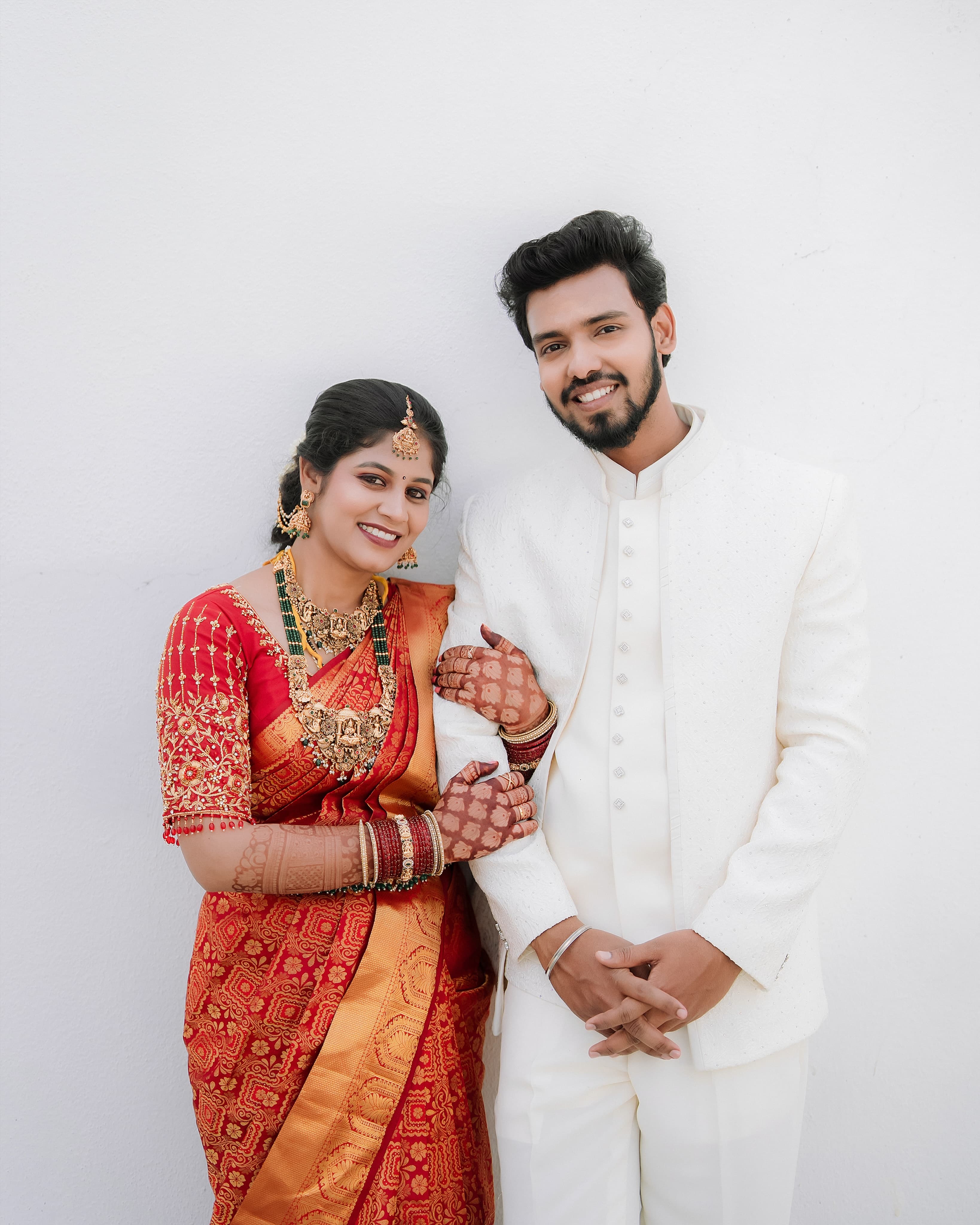 Bride in traditional crimson and gold Kanchipuram silk saree with poola jada hair adornment